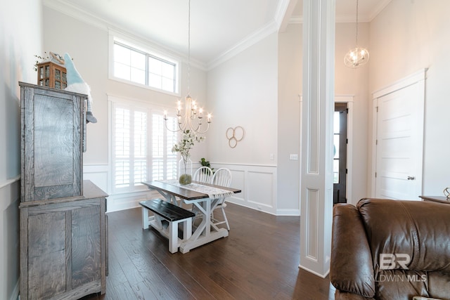 dining room featuring dark hardwood / wood-style flooring, crown molding, a high ceiling, and a chandelier