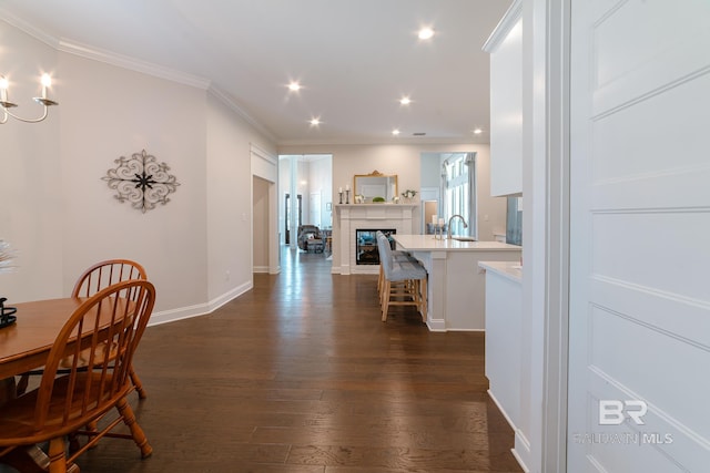 dining area with crown molding, dark hardwood / wood-style flooring, and sink