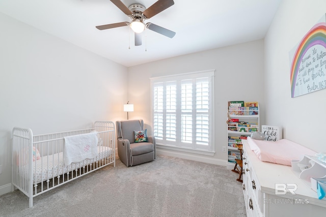 carpeted bedroom with a nursery area and ceiling fan