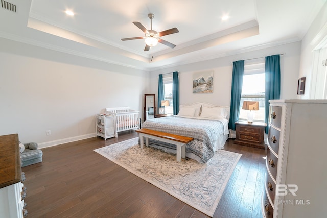 bedroom featuring a tray ceiling, ceiling fan, dark hardwood / wood-style floors, and ornamental molding