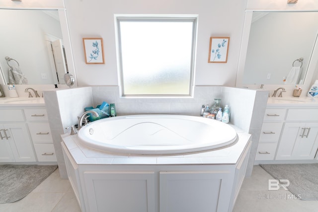 bathroom with tile patterned floors, tiled tub, and vanity