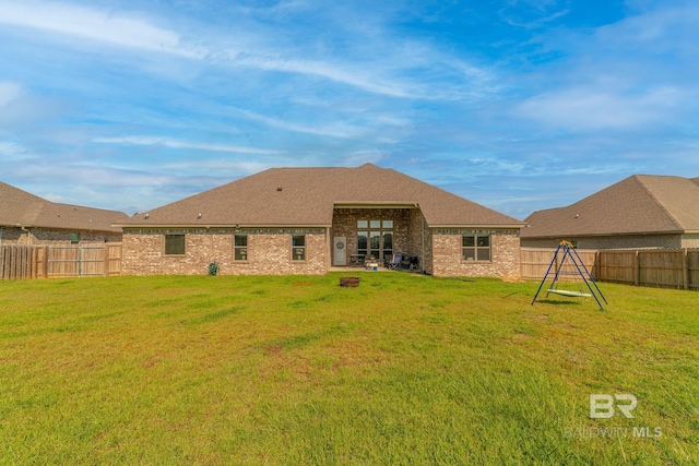 rear view of property with an outdoor fire pit and a lawn