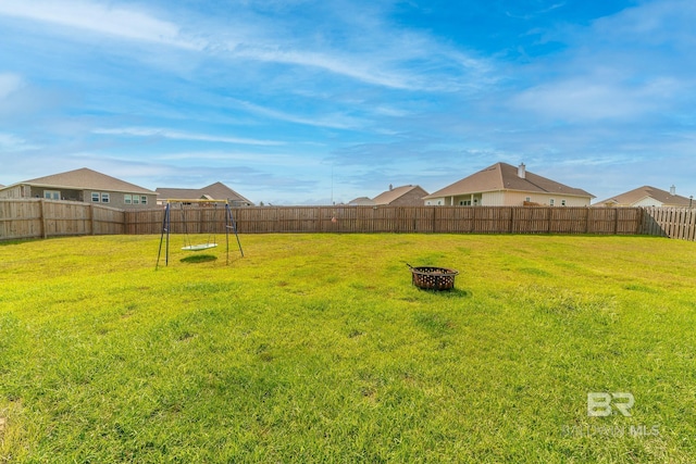 view of yard featuring a playground and an outdoor fire pit