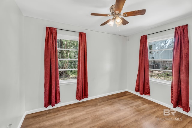 spare room with ceiling fan, plenty of natural light, and hardwood / wood-style floors