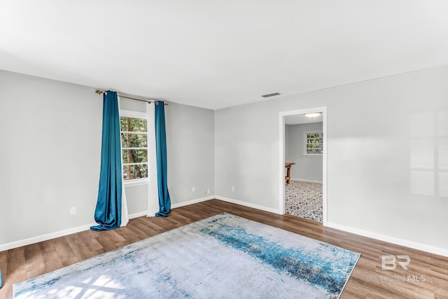 unfurnished room featuring hardwood / wood-style flooring and plenty of natural light