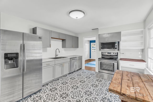 kitchen featuring gray cabinets, appliances with stainless steel finishes, and sink