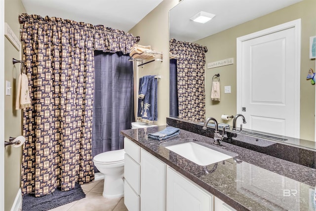 bathroom with curtained shower, toilet, vanity, and tile patterned floors