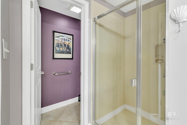 full bath with baseboards, tile patterned floors, and a shower stall