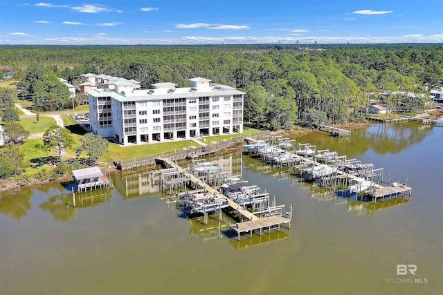 birds eye view of property featuring a forest view and a water view