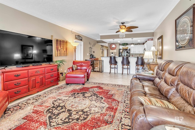 living area featuring light tile patterned floors, visible vents, ceiling fan, and crown molding