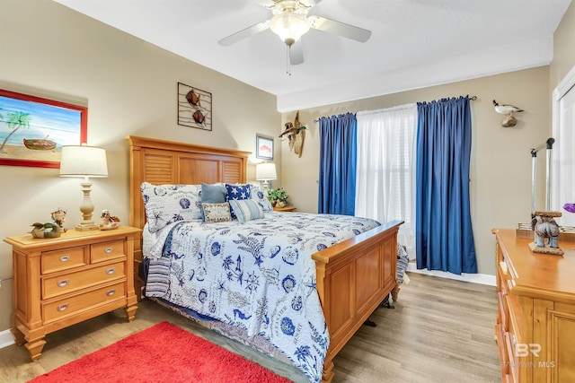 bedroom with light wood-style floors, ceiling fan, and multiple windows
