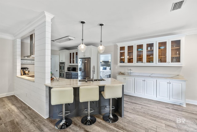 kitchen featuring white cabinets, appliances with stainless steel finishes, and light hardwood / wood-style flooring