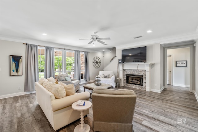 living room featuring hardwood / wood-style floors, ceiling fan, and crown molding