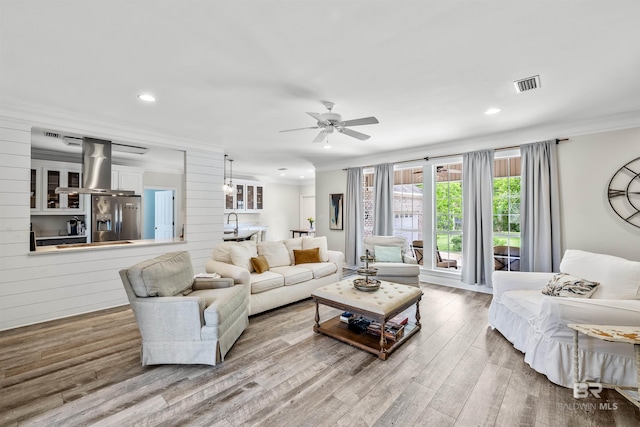 living room featuring crown molding, ceiling fan, and hardwood / wood-style floors