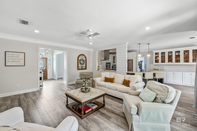 living room with sink, ceiling fan, light hardwood / wood-style floors, and ornamental molding