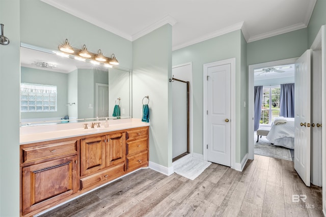 bathroom featuring crown molding, vanity, ceiling fan, hardwood / wood-style flooring, and a shower with shower door