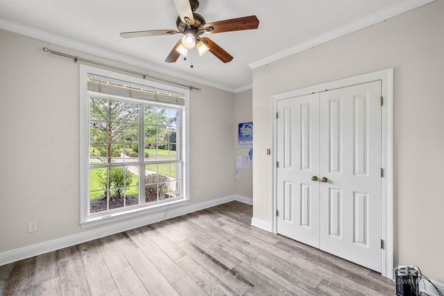 interior space featuring ceiling fan, ornamental molding, a closet, and light hardwood / wood-style floors