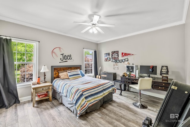 bedroom with ornamental molding, multiple windows, hardwood / wood-style flooring, and ceiling fan