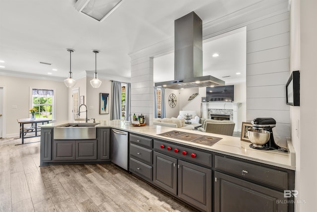 kitchen featuring crown molding, light hardwood / wood-style flooring, sink, a stone fireplace, and exhaust hood