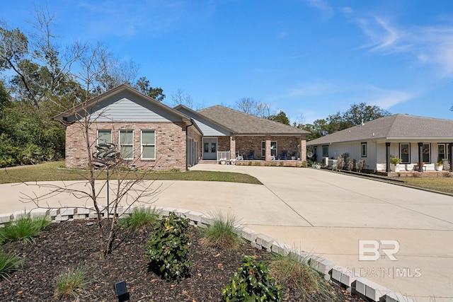 ranch-style house featuring concrete driveway and brick siding