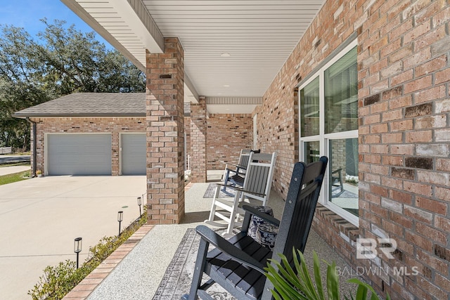 view of patio with driveway, covered porch, and an attached garage