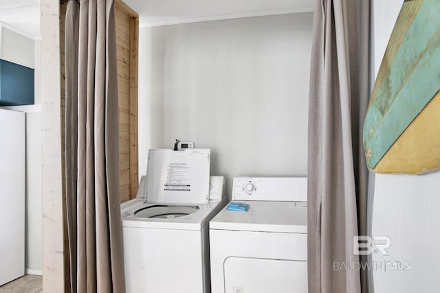 laundry area featuring wood walls, crown molding, and washer and clothes dryer