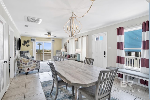 dining room with ornamental molding, ceiling fan with notable chandelier, and light tile patterned floors