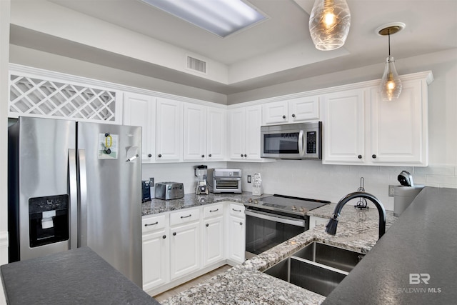 453 Dune Dr Unit 101, Gulf Shores, AL 36542 - kitchen featuring a sink, stainless steel appliances, tasteful backsplash, pendant lighting, and white cabinets