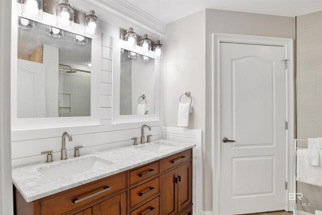 453 Dune Dr Unit 101, Gulf Shores, AL 36542 - bathroom with a tile shower, double vanity, and a sink