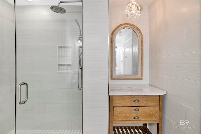 bathroom featuring tile walls, vanity, and an enclosed shower