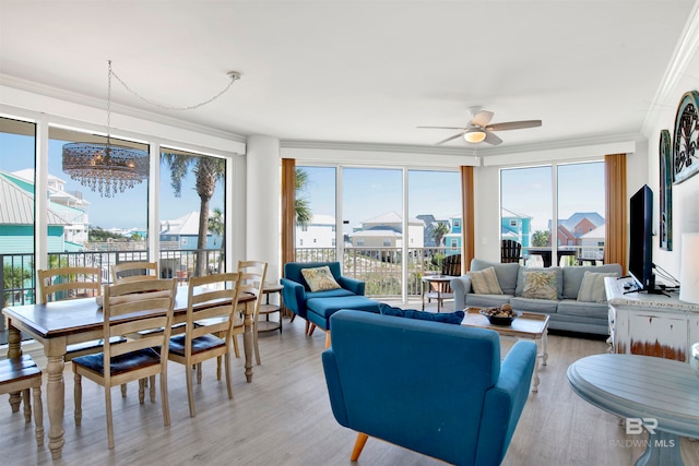 sunroom / solarium featuring ceiling fan with notable chandelier and plenty of natural light