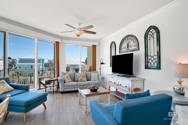 living room with crown molding, light wood-type flooring, and ceiling fan