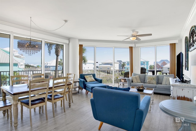 453 Dune Dr Unit 101, Gulf Shores, AL 36542 - living area featuring light wood-type flooring, a wealth of natural light, crown molding, and ceiling fan with notable chandelier