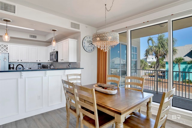 dining space featuring light hardwood / wood-style floors and an inviting chandelier