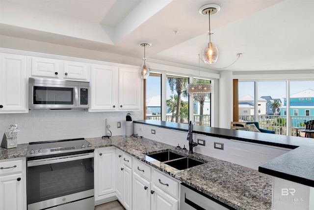 kitchen featuring white cabinetry, appliances with stainless steel finishes, sink, and pendant lighting