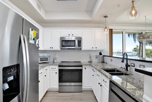 453 Dune Dr Unit 101, Gulf Shores, AL 36542 - kitchen with decorative backsplash, white cabinets, appliances with stainless steel finishes, and a sink