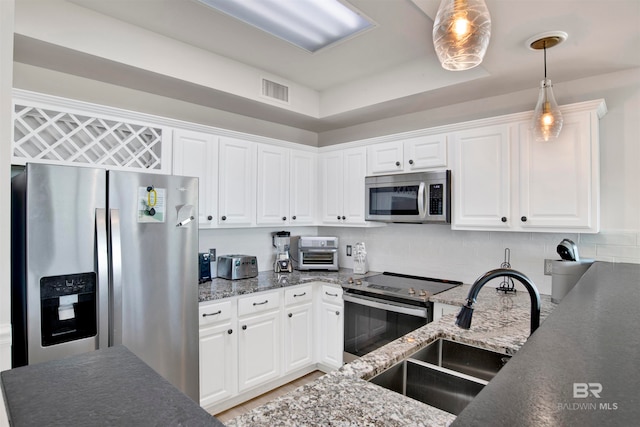 kitchen featuring stainless steel appliances, backsplash, sink, decorative light fixtures, and white cabinetry