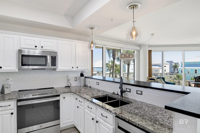 453 Dune Dr Unit 101, Gulf Shores, AL 36542 - kitchen with stainless steel appliances, white cabinets, decorative backsplash, and a sink