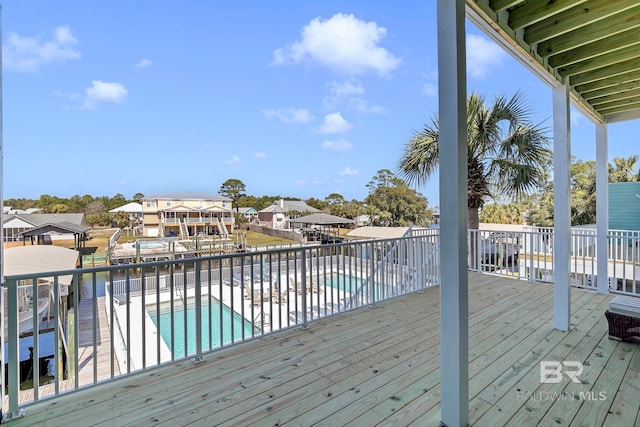 deck with a residential view, fence, and a community pool