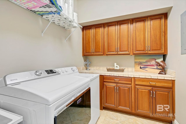 washroom featuring cabinet space, light tile patterned floors, and separate washer and dryer