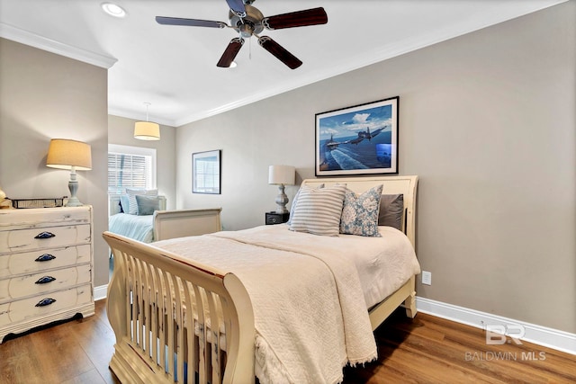 bedroom featuring baseboards, ornamental molding, ceiling fan, and wood finished floors