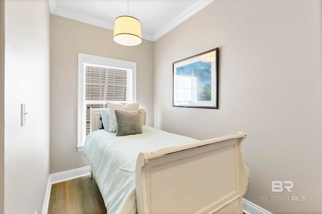 bedroom with baseboards, crown molding, and wood finished floors