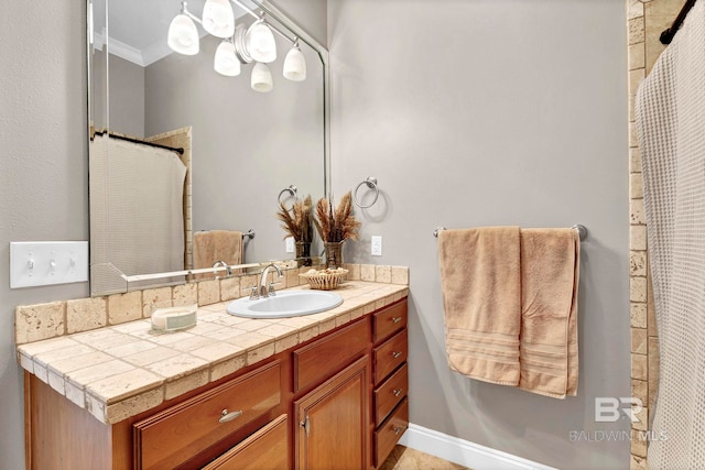 full bath with ornamental molding, vanity, and baseboards