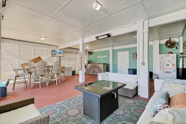 living area featuring a paneled ceiling and plenty of natural light