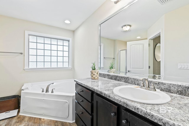 bathroom featuring a bathtub, vanity, and hardwood / wood-style floors