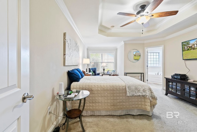 carpeted bedroom with ornamental molding, connected bathroom, ceiling fan, and a raised ceiling