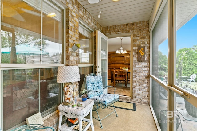 sunroom / solarium featuring an inviting chandelier and a healthy amount of sunlight