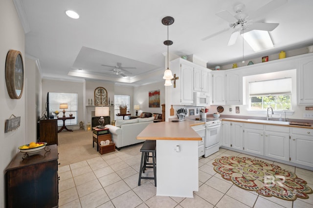 kitchen with white cabinetry, sink, a breakfast bar area, kitchen peninsula, and white appliances