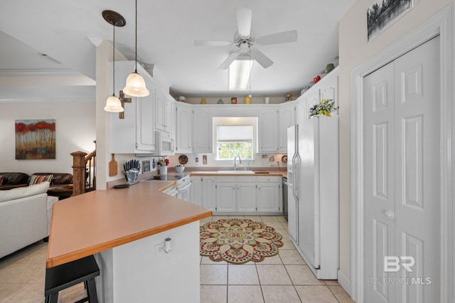 kitchen with sink, white cabinets, a kitchen bar, kitchen peninsula, and white appliances