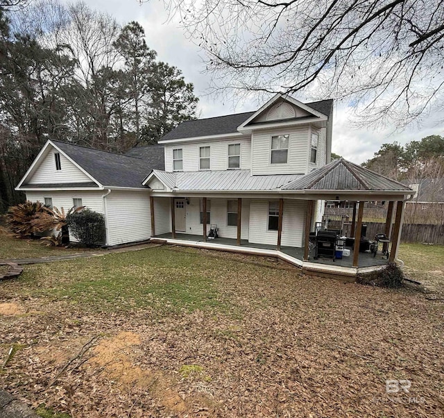 view of front of house featuring fence, metal roof, and a front yard